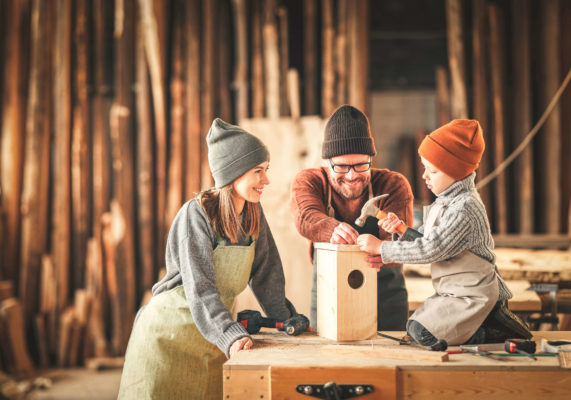 Family doing DIY with baby building bird feeder