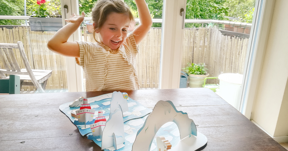 little girl plays with the game Polar Adventure which teaches how to save animals in danger from melting ice