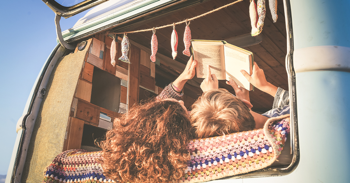 Mom and son travelling on mini-van reading book